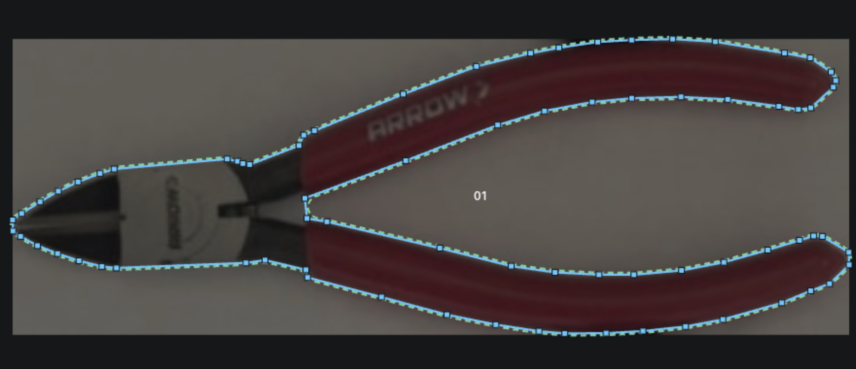 A photo of a pair of pliers on a plain sheet, with Shadow Forge's traced outline and cut contour laid over it.
